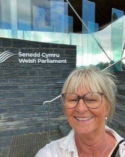 Woman standing outside Senedd Cymru Welsh Parliament